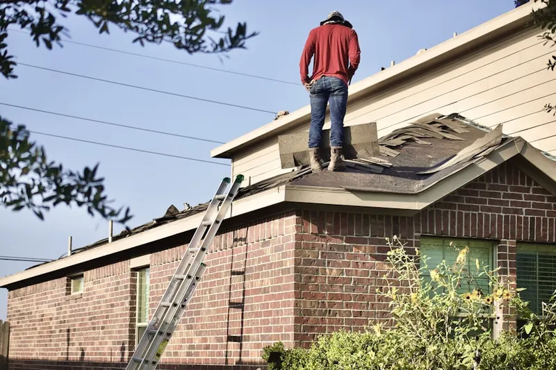 Professional roofer working on a residential roof in Monfort Heights East